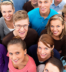 photo of many smiling peopple looking up at camera